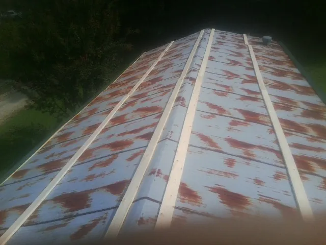 Rusted metal roof panels with new wood purlins before replacement — Storm Damage Roof Repair in Saint George by Roofing Brothers