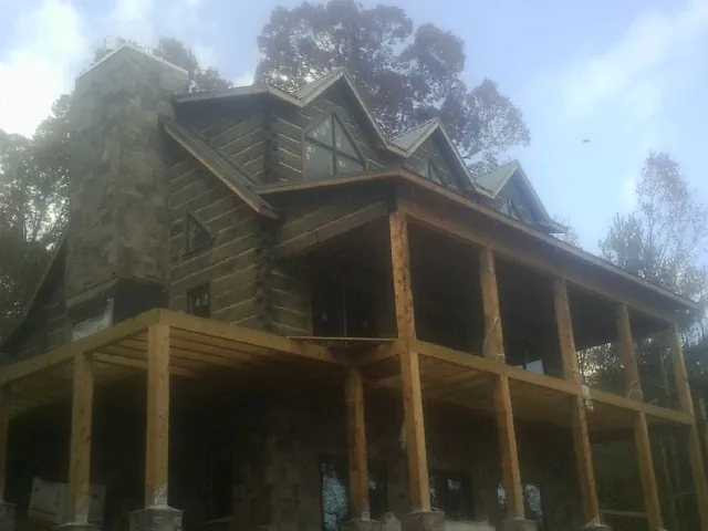 Stone chimney and dormers on a large log home with a timber porch in Saint George